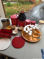 Wide view showing all items including the tins, thermos, spice jars on wood tray, trivets, small bowls, and glass jar.