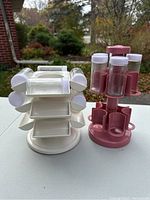 Front view of white and pink Copco spice racks with plastic spice containers attached
