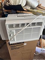 Front view of Arctic King window air conditioner showing control dial and vents.