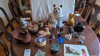 Full view of various animal-themed decor items including cookie jar, figurines and music box on a wooden dining table