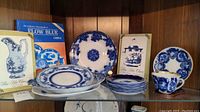Shelf with various flow blue china plates, cups, saucers and three books on flow blue china collecting