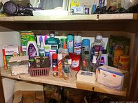 Wide view of assorted toiletry and personal care items arranged on a shelf, showing variety of brands and products