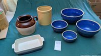 Full set of crockery items on cloth background: wide-mouth jug, utensil crock, baking dish, and nesting bowls.