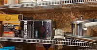 Photo of shelf with boxed Presto Fry Daddy electric deep fryer and Omega Mega Mouth juicer, small Black & Decker Handy Chopper, Continental Platinum pressure cooker, and warming tray