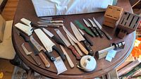 Overview of all knives, sharpeners and blocks on a table showing full assortment and quantity.
