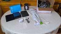 View of Samsung Galaxy Tab A tablet with cover, original blue box, NXT timer and wall charger boxes, power strip, and multiple cords spread on a table
