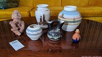 Collection of six southwestern and Aztec-style pottery and terra cotta figure pieces displayed on table