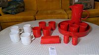 Photo showing full lot arranged on table with all white and red plastic serving items visible