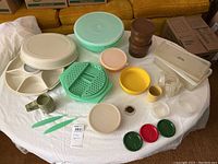 Wide view of all items laid out on a table including storage containers, measuring cups, divided serving tray, lids, and utensils.