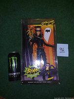Image of the Barbie Pink Label Catwoman 2012 doll in the original box, next to a Monster Energy drink can for size reference.
