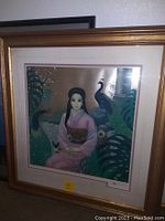 Frontal view of framed print showing woman in pink kimono with peacocks