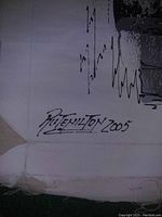 Close-up photo showing artist's signature and date 'Rutenilton 2005' on the bottom left corner