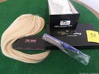 Top piece, comb, box, and informational card displayed on green surface