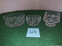 Three crystal bowls on green felt surface with lot number 124, side view showing shape and cut details.