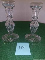 Pair of Waterford crystal candle sticks standing upright on green felt, showing full height and cut detail.