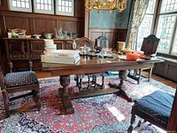 Full view of extended table top with assorted contents on surface, carved pedestal supports visible