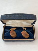 Antique pair of 10K gold cufflinks in original lined presentation box, showing front design with engraved lines.