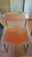 Front view of leather chair showing the seat and backrest with visible stains and marks.