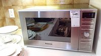 Full view of the Panasonic microwave oven showing the stainless steel finish and control panel on the right side.