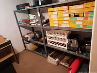 View of two metal shelving units filled with various boxes and items, showing condition and size relative to contents.