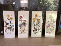 Full view of the four floral prints side by side showing different colorful flowers with white backgrounds and thin gold borders.