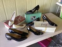 Four pairs of vintage designer women's shoes displayed with mostly original boxes.