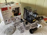 Photo showing the Emeril Lagasse pasta maker with all attachments and the box in the background.
