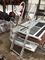 Two aluminum ladders stacked with handrails visible