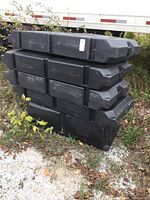 Stacked black plastic dock float modules, five pieces visible