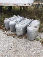 Four grey floats on gravel with trailer in background
