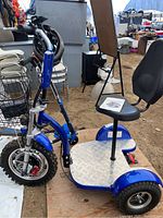 Front-left perspective showing overall scooter frame, basket, seat and manual on seat