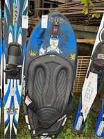 Front view of blue and black kneeboard with padded seat and adjustable strap, showing overall design and wear.