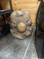 Front view showing the monk's bowed head, curled fingers, and detailed rounded form.