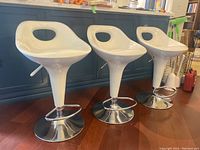 Three stools side by side in front of kitchen counter