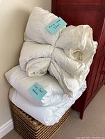 Two stacked white bedding items labeled as king size duvet and king size comforter.
