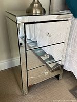 Front side view showing the three mirrored drawers and overall mirrored composite frame with beveled edges.