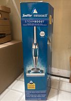 Photo of unopened Swiffer Bissell Steamboost mop box showing front view with product image and branding.
