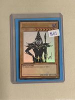 Close-up of the Dark Magician Limited Edition Yu-Gi-Oh! card in a protective sleeve showing artwork, stats, signature, and price sticker.