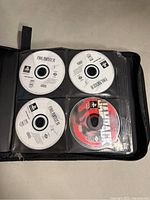 Loose PS1 game discs in plastic sleeves inside a zipped binder. Final Fantasy IX disc and others visible.