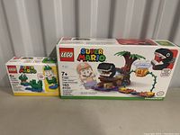 Two Lego Super Mario boxed sets side by side on table, showing box art and model images.