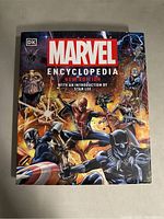 Front cover of Marvel Encyclopedia New Edition showing multiple Marvel characters including Spider-Man, Thanos, and Black Panther.