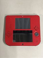 Front view of Nintendo 2DS showing screens, control buttons, and red color body.