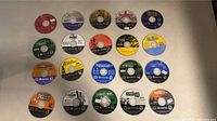 Top view of 20 Nintendo GameCube game discs arranged on a flat surface showing various game titles and condition with some price tags.