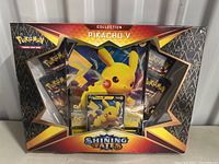 Front view of sealed Pokemon Shining Fates Pikachu V collection box showing the promo card and booster packs inside.