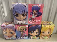 Front view of 7 boxed Qposket figures including anime and pop culture characters.