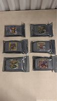 Six Nintendo 64 reproduction game cartridges sealed individually in anti-static bags, arranged in two rows on a flat surface.