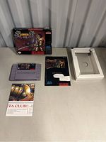 Overview of lot items including game box, cartridge, instruction manual, cardboard tray insert, and promotional club insert