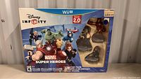 Front view of the original sealed Disney Infinity Marvel Super Heroes 2.0 Edition Starter Pack for Wii U, showing the box art and three character figures visible in packaging.