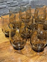 14 smokey brown tulip glasses arranged on wood surface showing shape and color