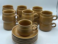 Set of 13 cups stacked in two piles and 6 saucers stacked together, showing overall quantity and condition